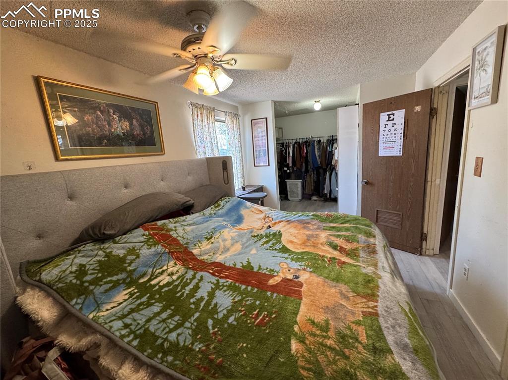 Image 20 of 22: Bedroom featuring wood finished floors, a textured ceiling, and ceiling fan
