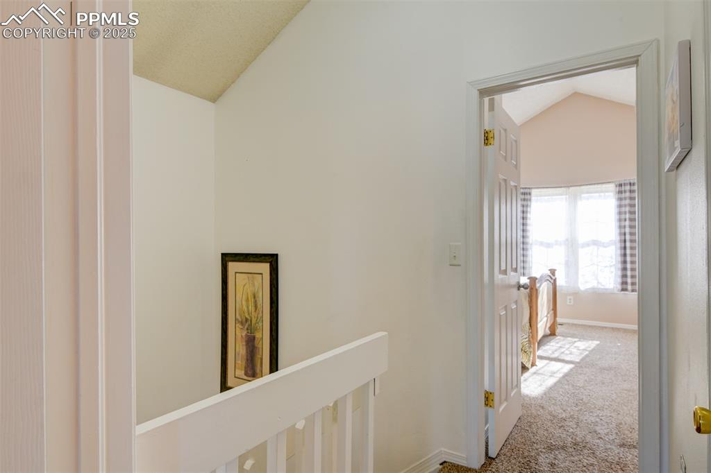 Image 13 of 25: Hall on the upper level leading to the main bedroom with lofted ceiling, ca