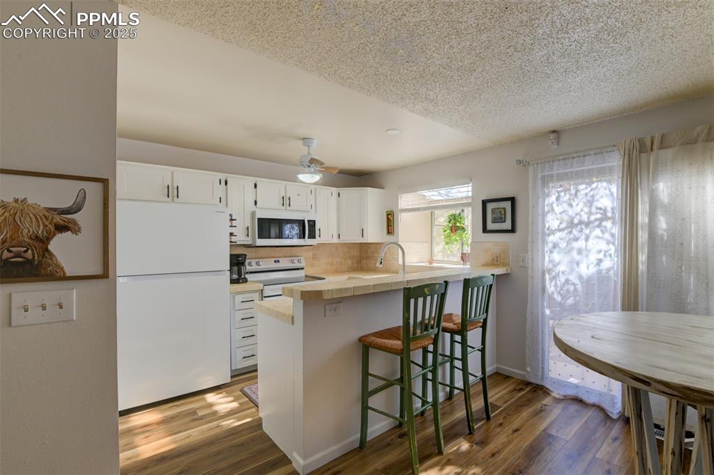 Image 6 of 25: Kitchen on the main level featuring white new 2025 appliances, white cabine