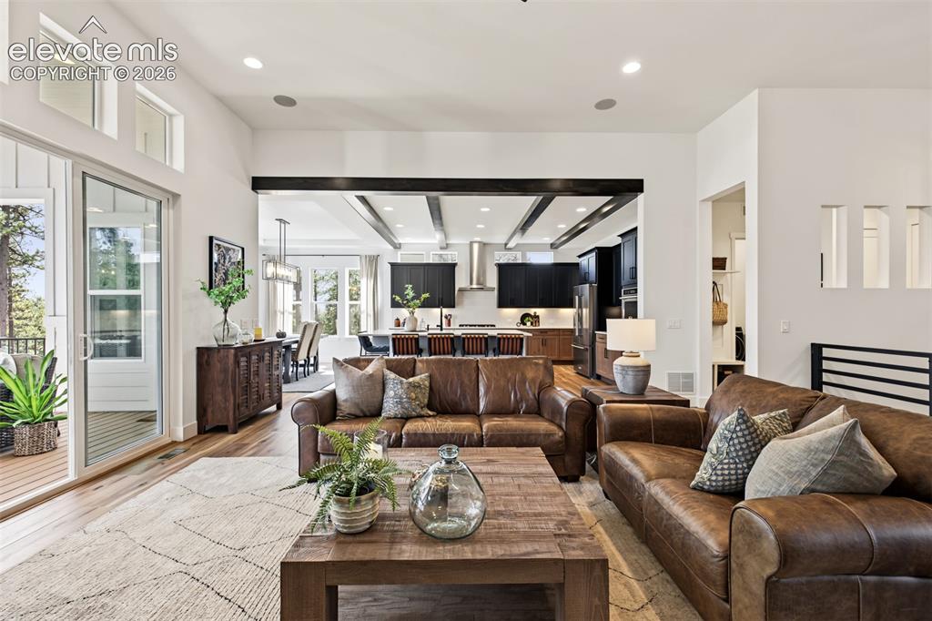 Image 12 of 50: Spacious, light-filled great room featuring expansive windows, soaring ceil