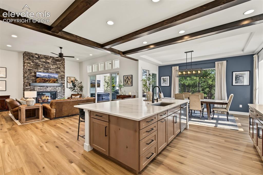 Image 15 of 50: Open-concept living space featuring exposed wood beam ceiling details, rece
