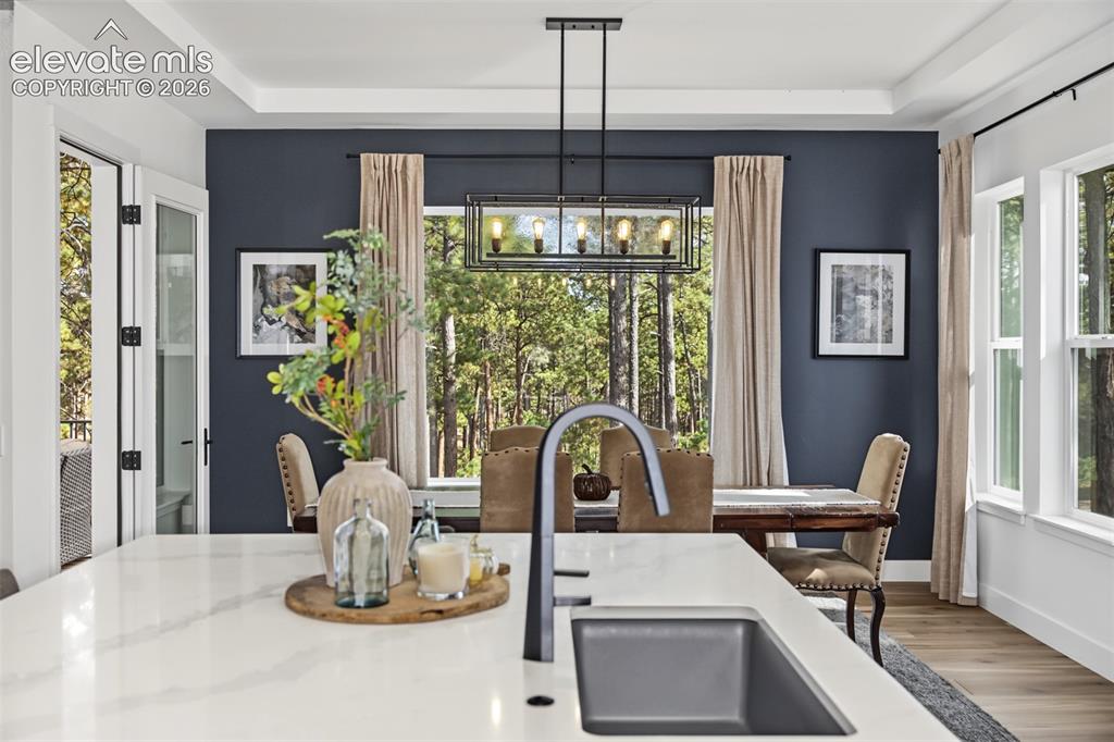 Image 18 of 50: Spacious covered deck overlooking beautiful mature trees, offering a peacef