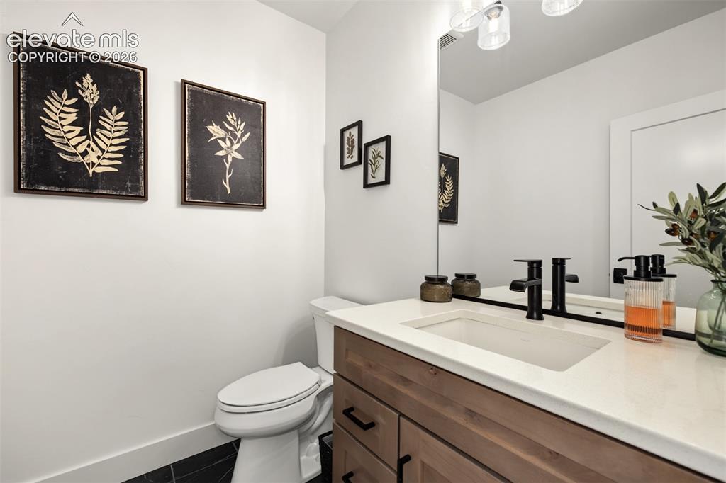 Image 38 of 50: Wood-finish vanity with undermount sink, white countertop, and matte black 