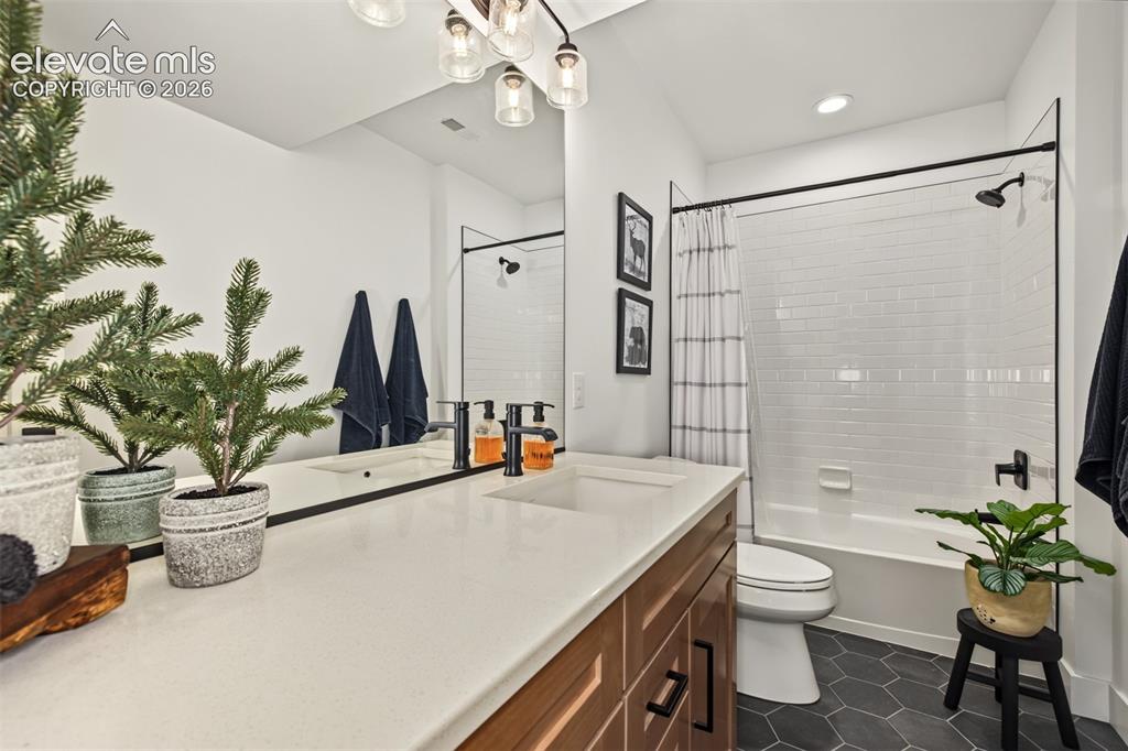 Image 40 of 50: Dual vanity with undermount sinks and wood-finish cabinetry