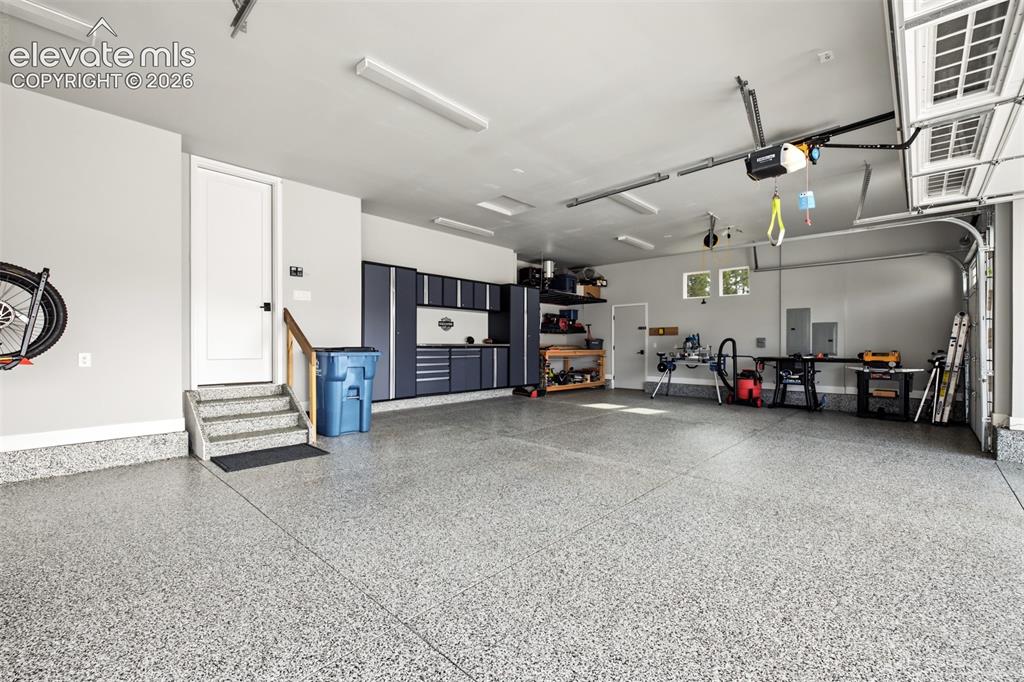 Image 42 of 50: Impressive oversized four-car garage featuring professionally installed flo