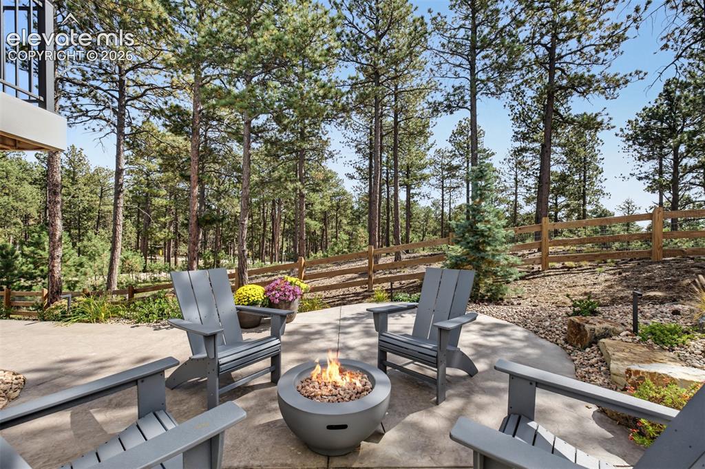 Image 47 of 50: Beautifully landscaped outdoor retreat featuring a custom fire pit and spac