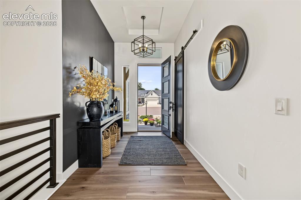 Image 5 of 50: Welcoming entryway featuring beautiful wood flooring, elegant chandelier li