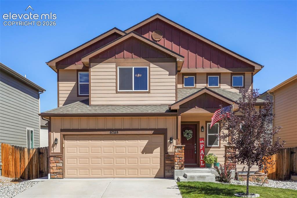 Caption: Two-story residence featuring a covered front entry, attached two-car garage, and a combination of s