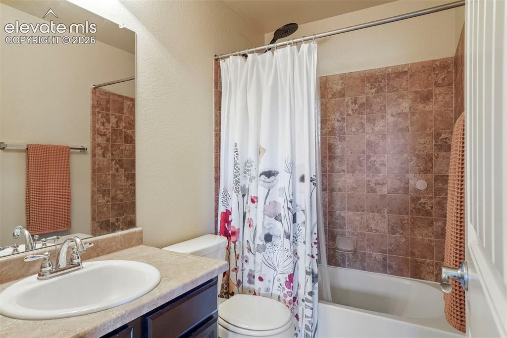 Image 19 of 32: Integrated vanity with an oval sink, chrome faucet, and tan-toned counterto