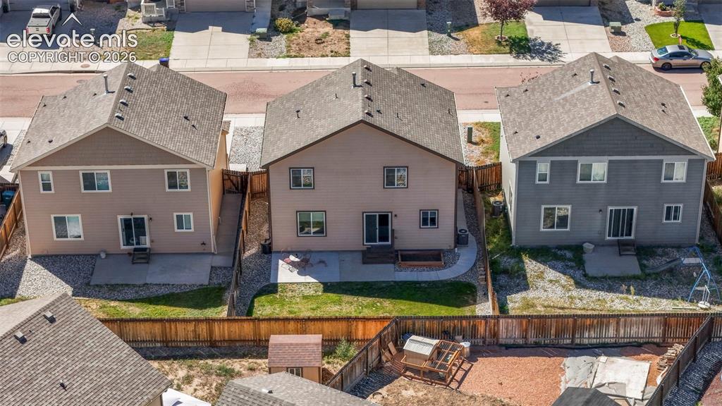 Image 29 of 32: Rear exterior with private fencing, ground-level patio, and sliding glass d