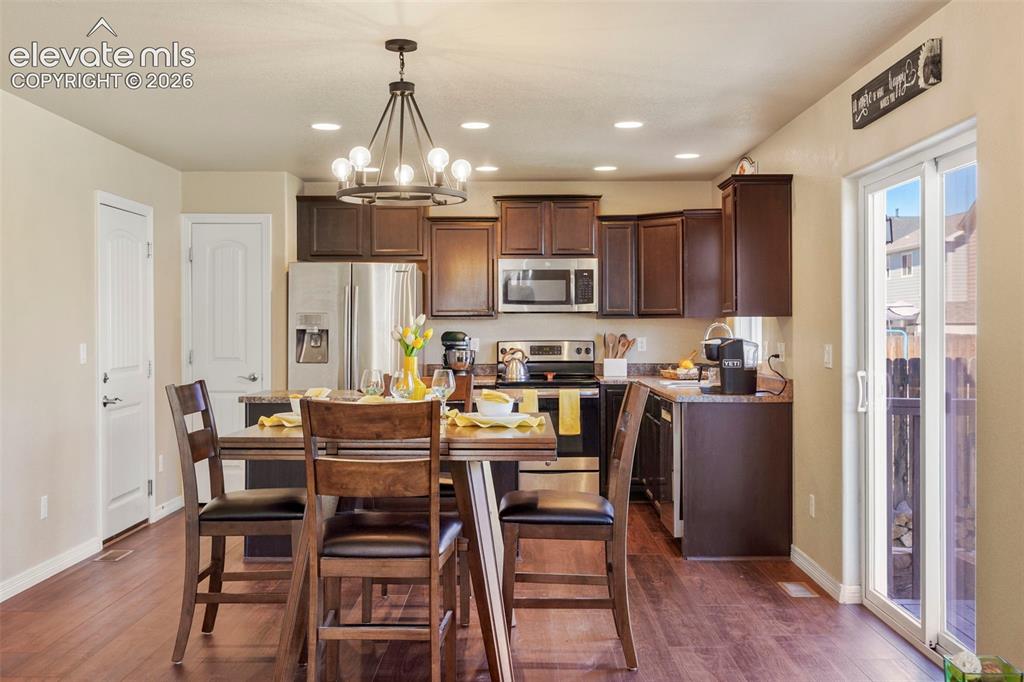 Image 5 of 32: Kitchen featuring dark wood-finish cabinetry, stainless steel appliances, r