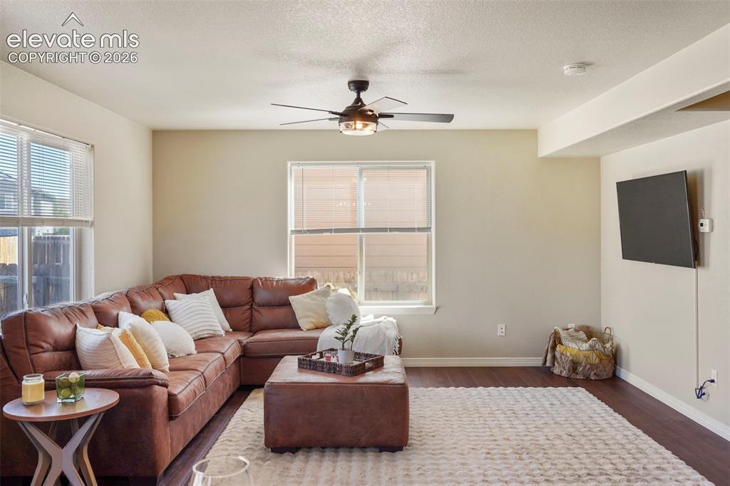 Image 7 of 32: Living area featuring wood-finish flooring, a ceiling fan with integrated l