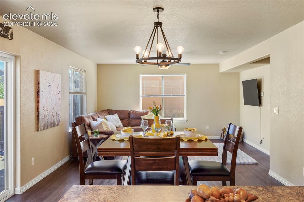 Image 8 of 32: Open-concept living area featuring wood-finish flooring, a dining space wit