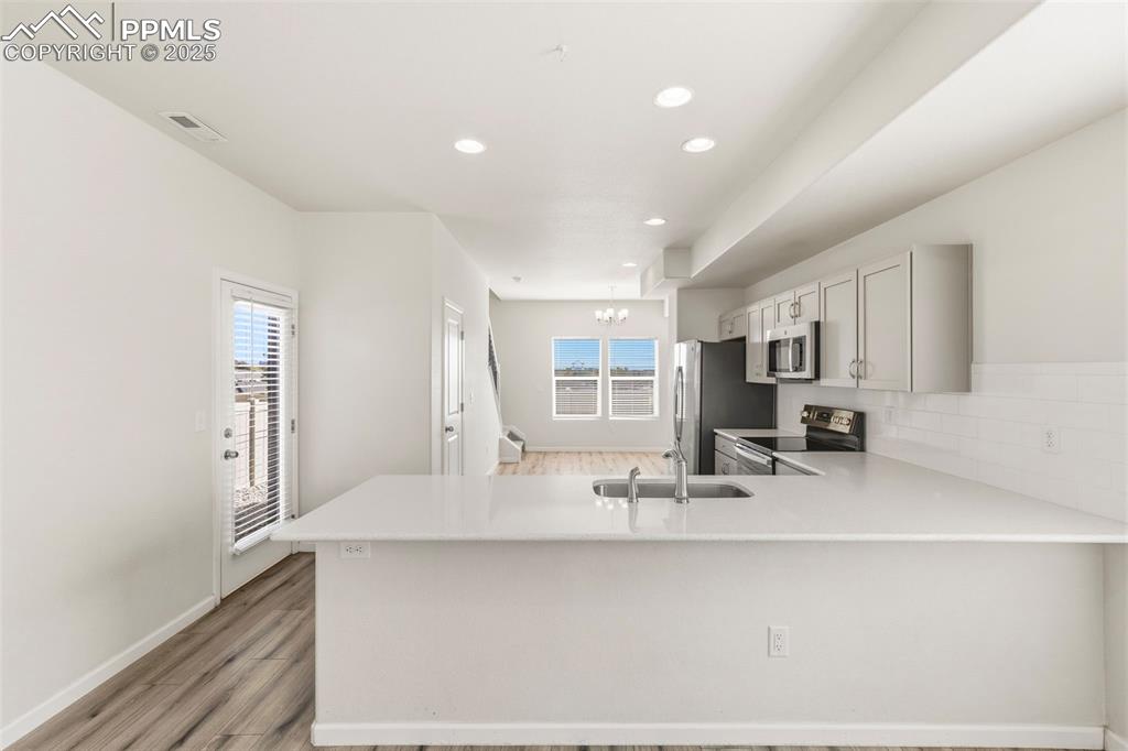 Image 11 of 35: Kitchen featuring stainless steel appliances, a peninsula, recessed lightin