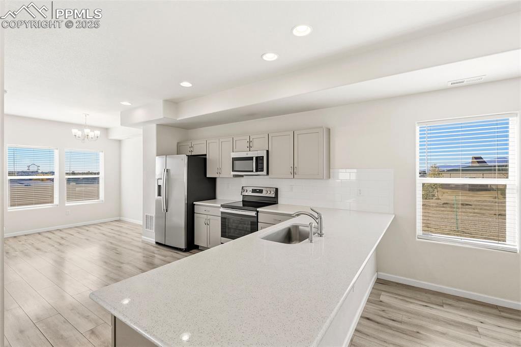 Image 12 of 35: Kitchen with appliances with stainless steel finishes, healthy amount of na