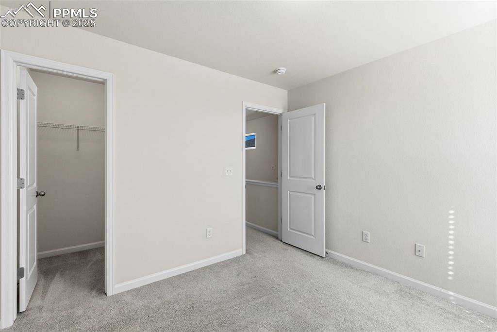 Image 18 of 35: Unfurnished bedroom with a spacious closet and light carpet