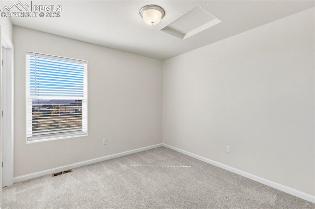 Image 19 of 35: Unfurnished room with attic access and light carpet