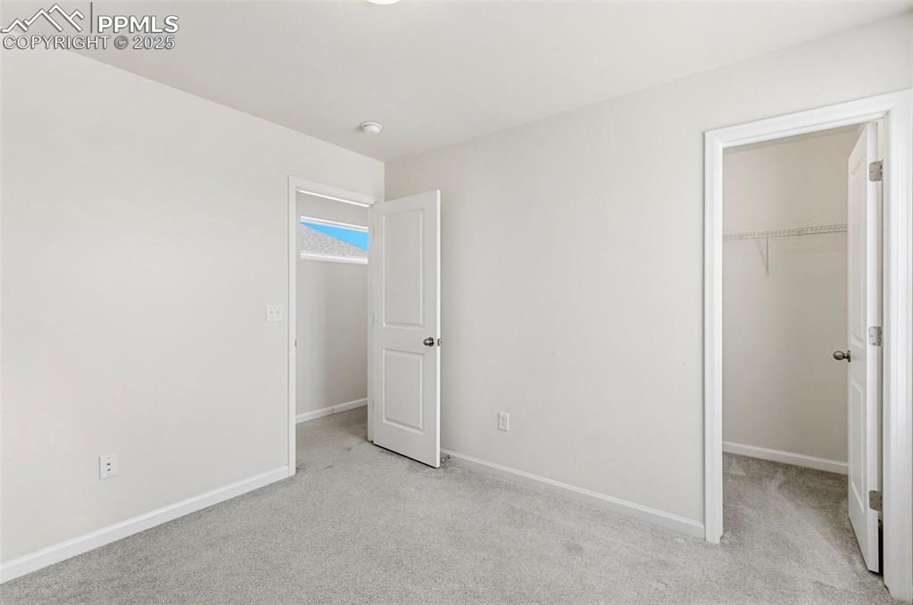 Image 20 of 35: Unfurnished bedroom with a spacious closet and light colored carpet