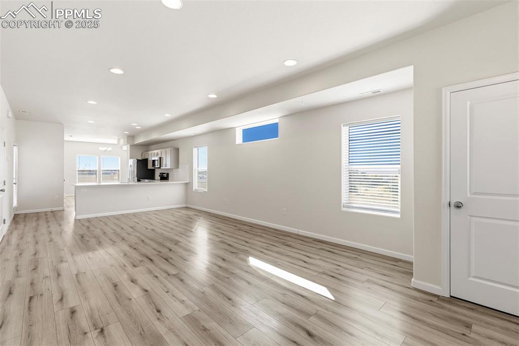 Image 6 of 35: Unfurnished living room with recessed lighting and light wood finished floo