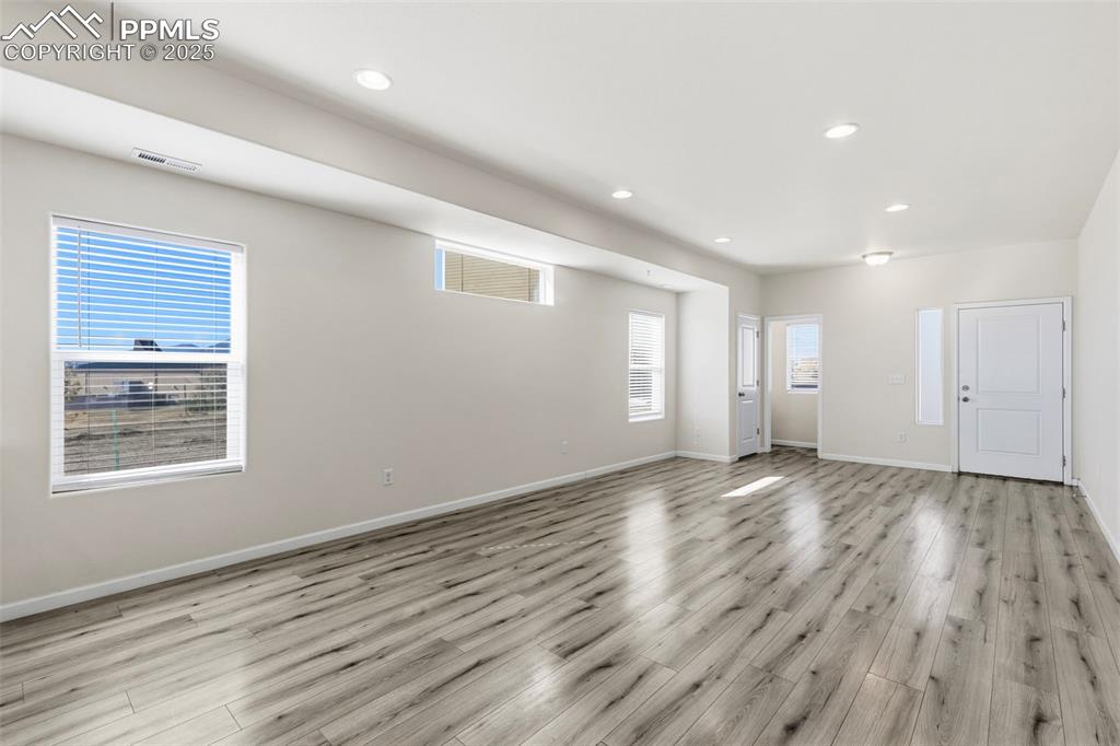 Image 9 of 35: Empty room featuring light wood-style flooring and recessed lighting