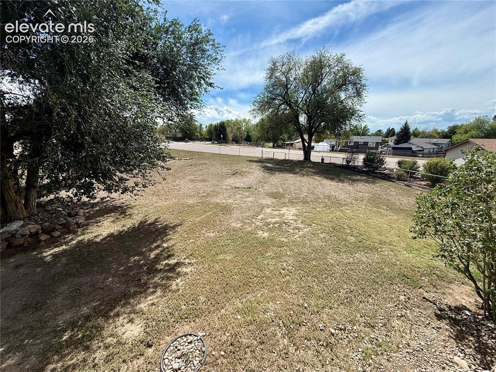 Image 23 of 25: large accessible backyard with rear fence.