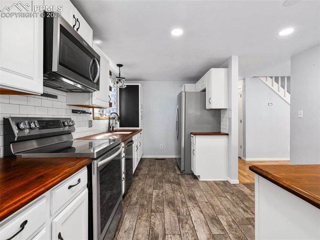 Image 10 of 29: Kitchen featuring stainless steel appliances, butcher block counters, white