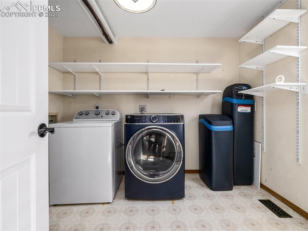 Image 17 of 29: Laundry area featuring tile patterned floors and washer and clothes dryer