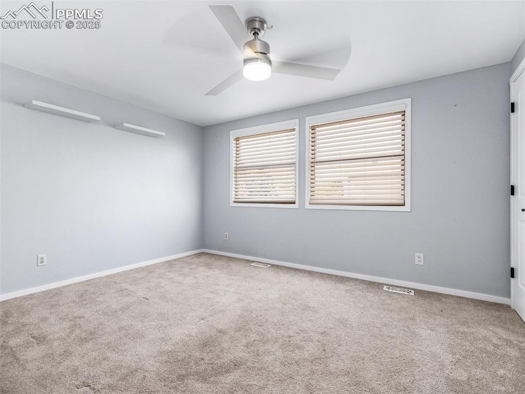Image 19 of 29: Empty room featuring light colored carpet and ceiling fan