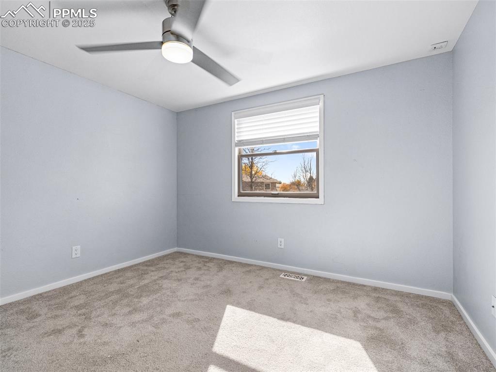 Image 21 of 29: Spare room featuring carpet and ceiling fan