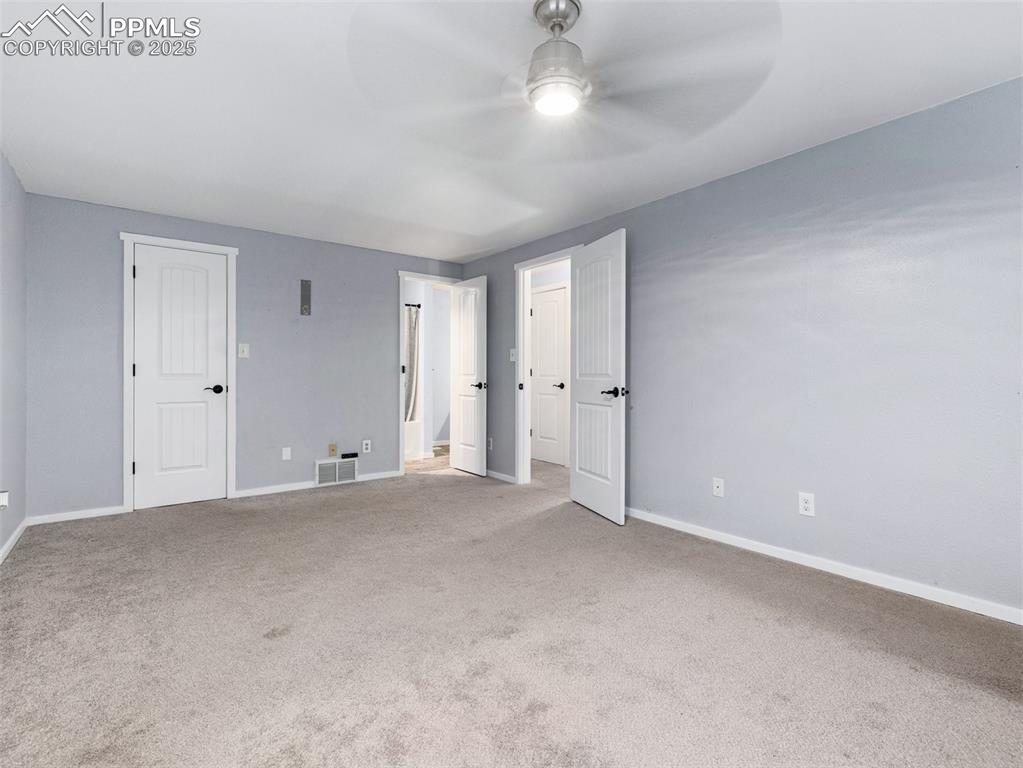 Image 25 of 29: Unfurnished bedroom with carpet flooring and a ceiling fan