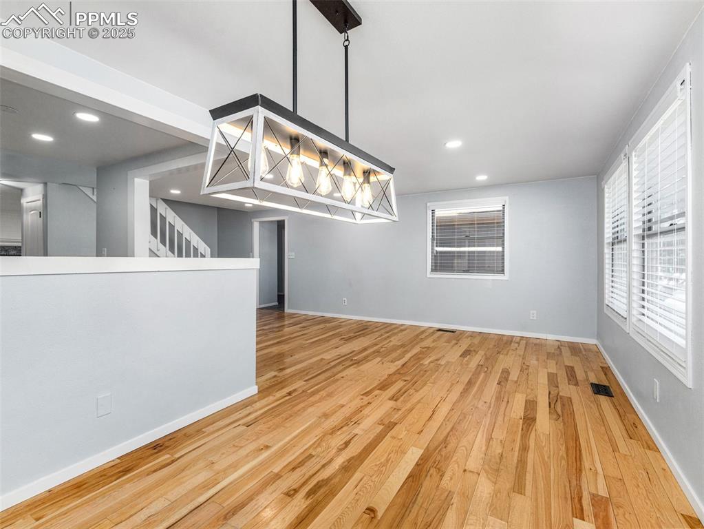 Image 8 of 29: Unfurnished dining area with light wood-style flooring and recessed lightin