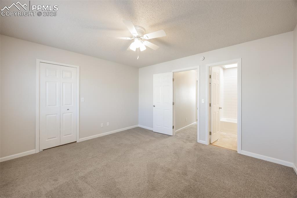 Image 13 of 25: Unfurnished bedroom with carpet flooring, baseboards, a textured ceiling, e