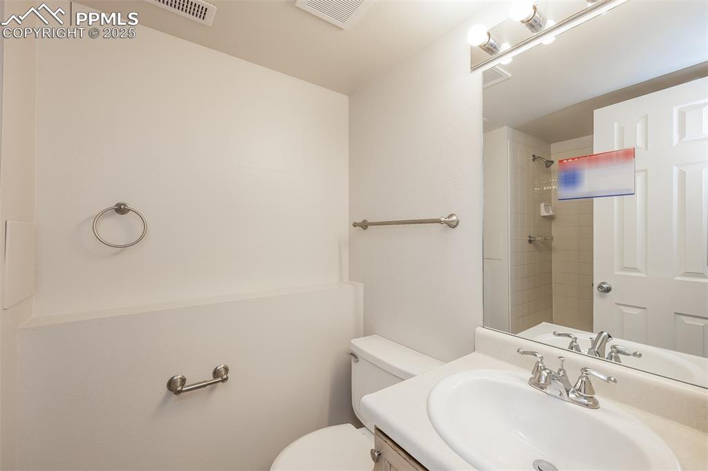 Image 23 of 25: Full bath featuring a shower, toilet, and vanity