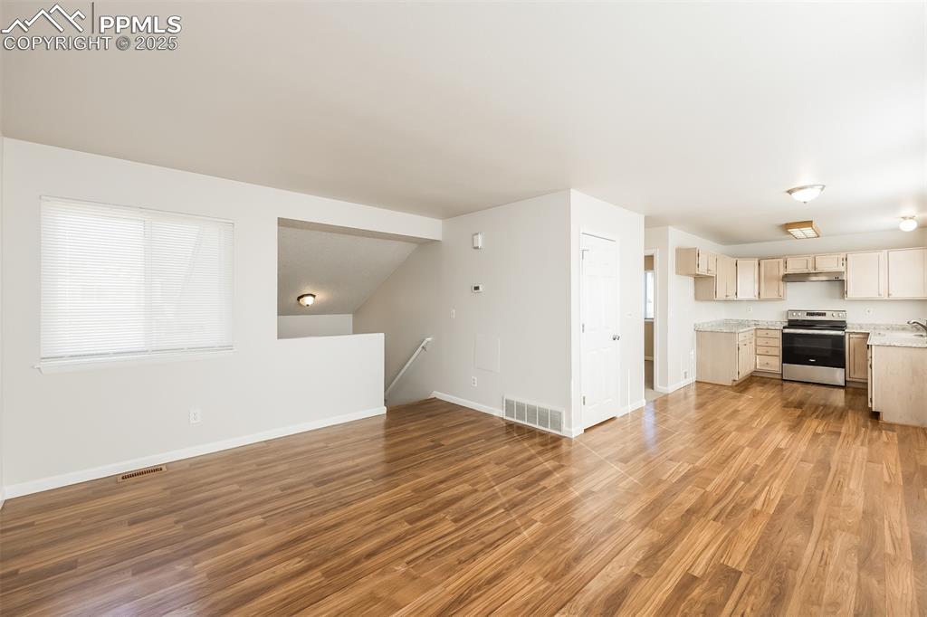 Image 4 of 25: Unfurnished living room with light wood-type flooring and baseboards