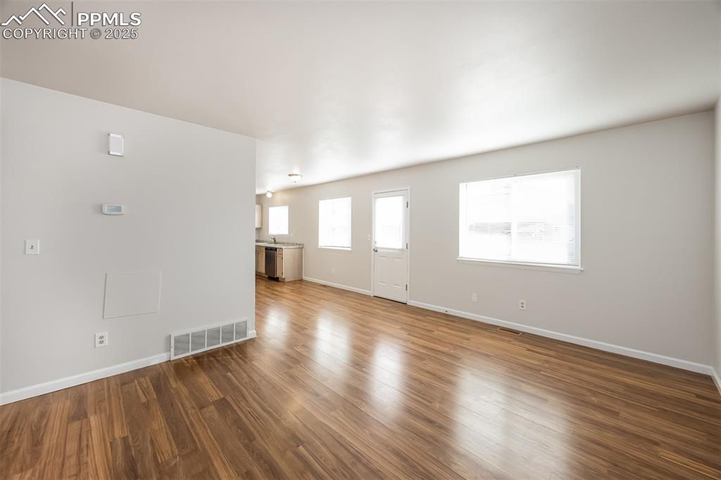 Image 5 of 25: Unfurnished living room featuring baseboards and wood finished floors