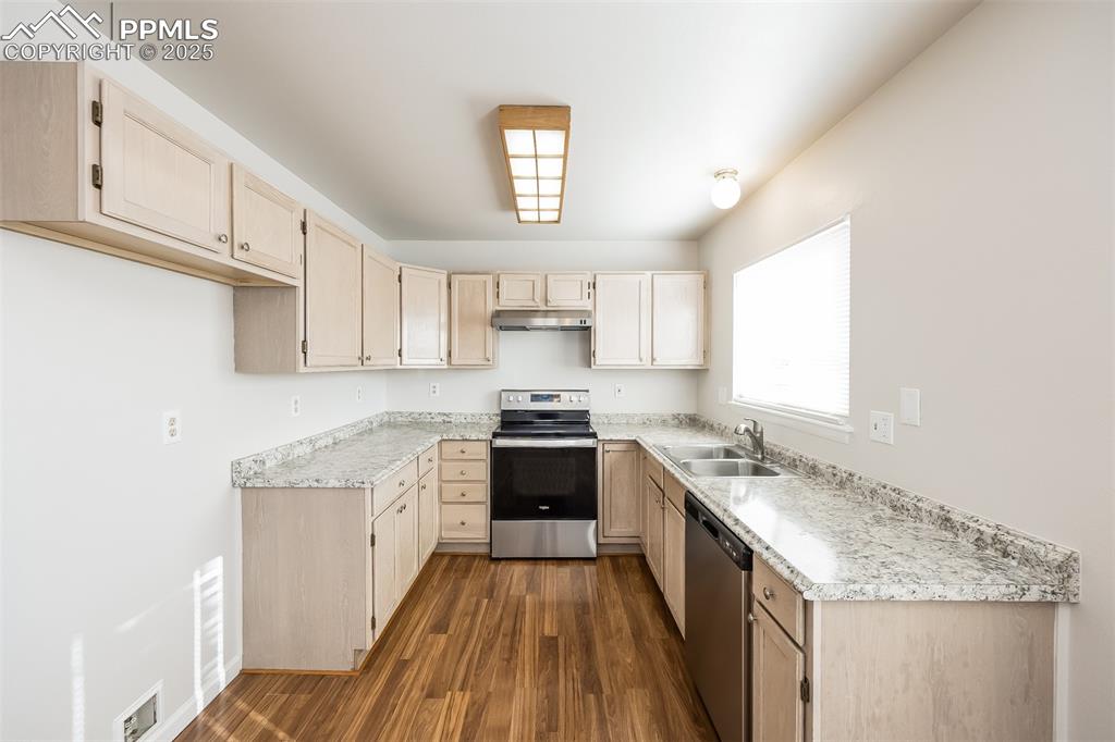 Image 7 of 25: Kitchen featuring stainless steel appliances, a sink, under cabinet range h
