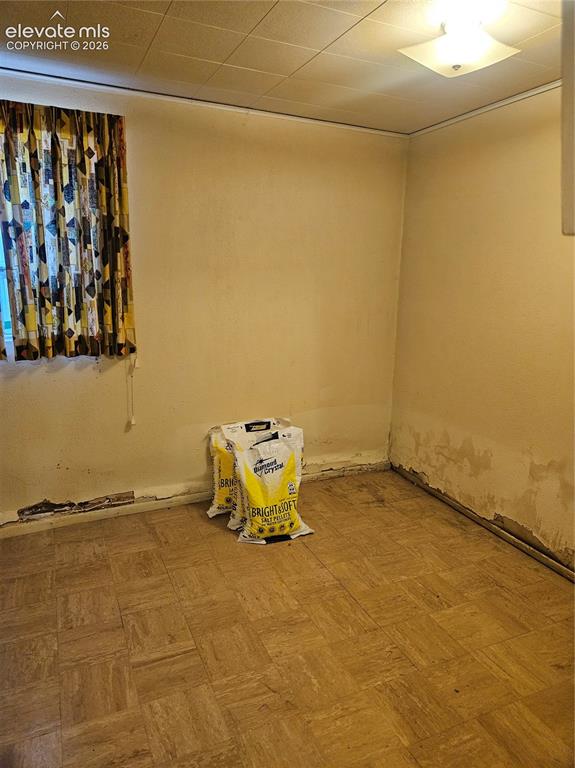 Image 27 of 37: Extra room w/ closet in the basement. Notice damage to the bottom of the wa