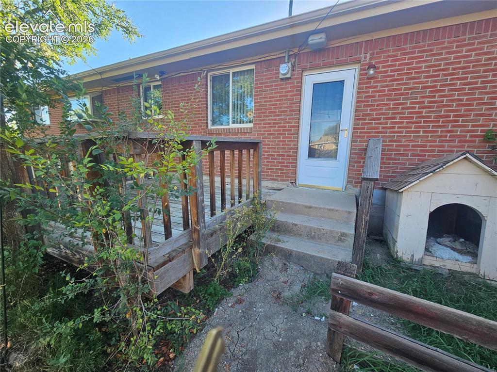 Image 31 of 37: Red brick exterior and wood deck.