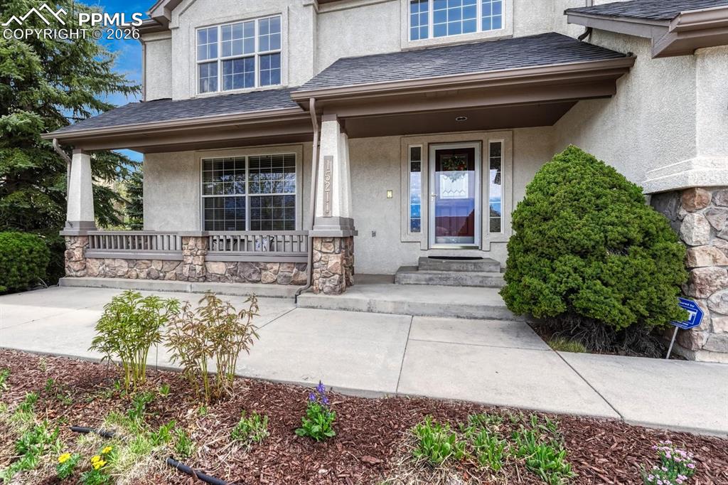 Image 2 of 47: Large covered porch with patio to take in sweeping front range views!