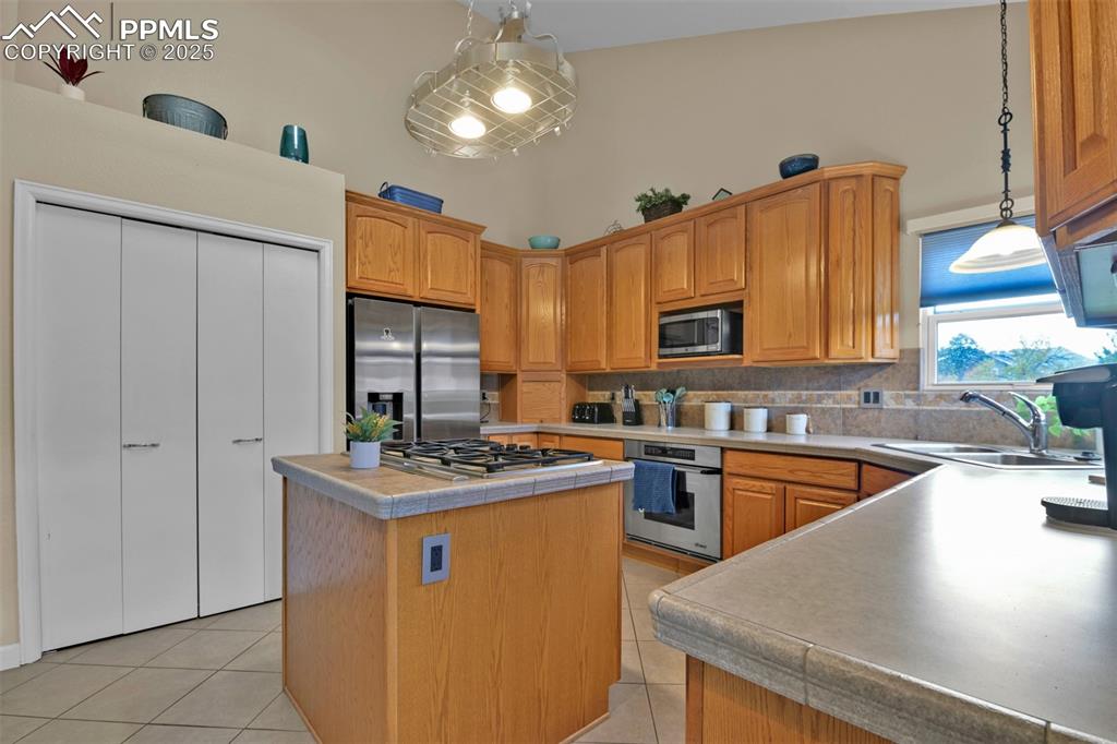 Image 12 of 50: Kitchen featuring appliances with stainless steel finishes, light tile patt