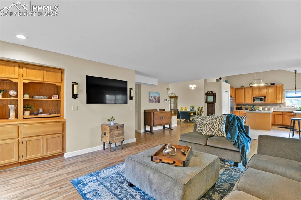 Image 19 of 50: Living area featuring a chandelier, light wood-type flooring, and recessed