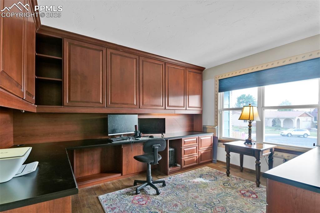 Image 21 of 50: Home Office featuring wood finished floors and built in study area