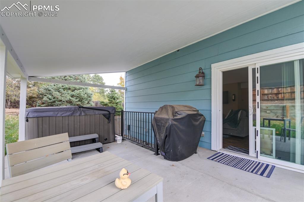 Image 24 of 50: Deck with a hot tub and a grill