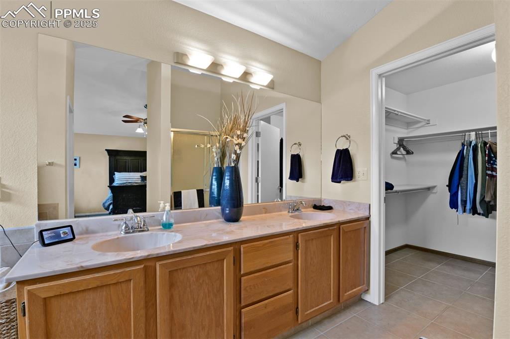 Image 28 of 50: Full bath featuring light tile patterned floors, double vanity, and a ceili