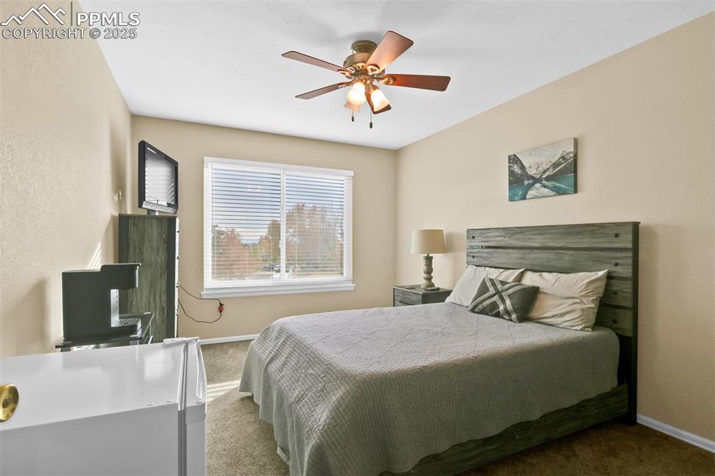 Image 34 of 50: Carpeted bedroom featuring a ceiling fan