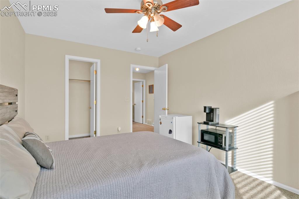 Image 35 of 50: Carpeted bedroom with ceiling fan and a spacious closet