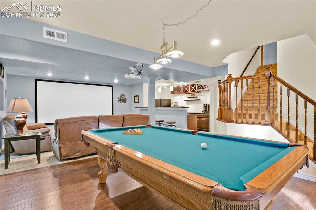 Image 37 of 50: Recreation room featuring bar, wood finished floors, pool table, and recess