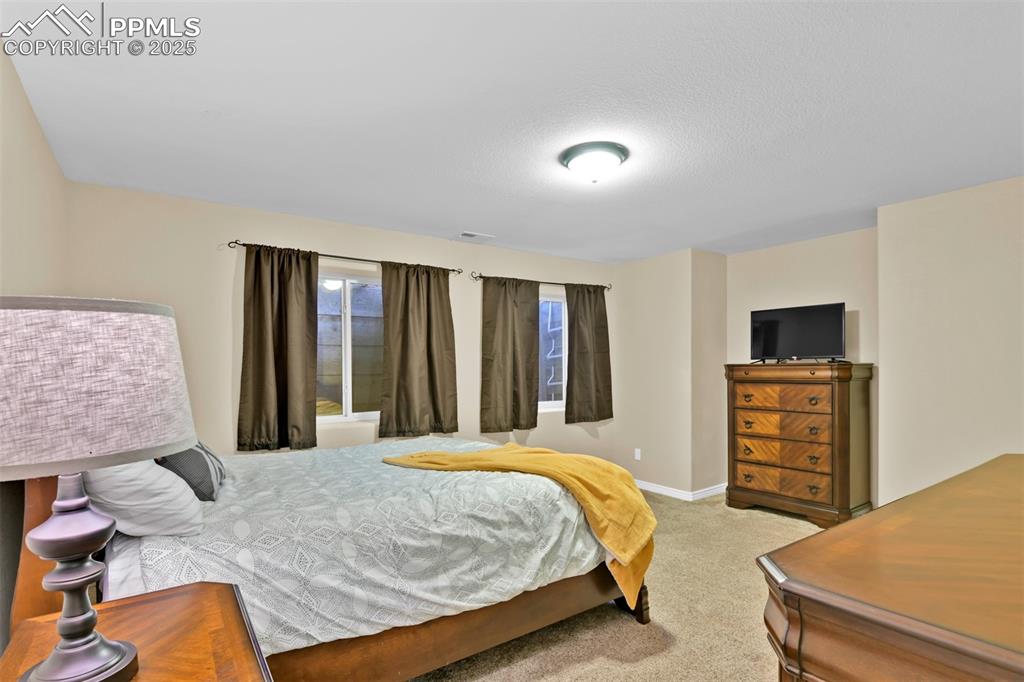 Image 42 of 50: Bedroom with light colored carpet and a textured ceiling