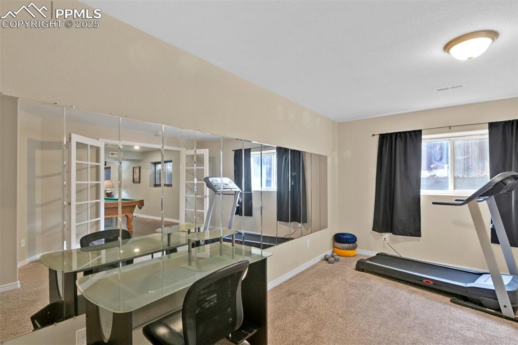 Image 46 of 50: Workout area with carpet flooring and billiards