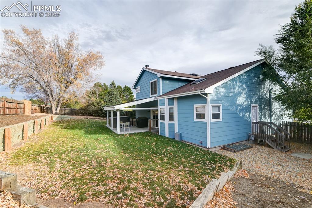 Image 48 of 50: Back of house with a fenced backyard, a patio, and a shingled roof